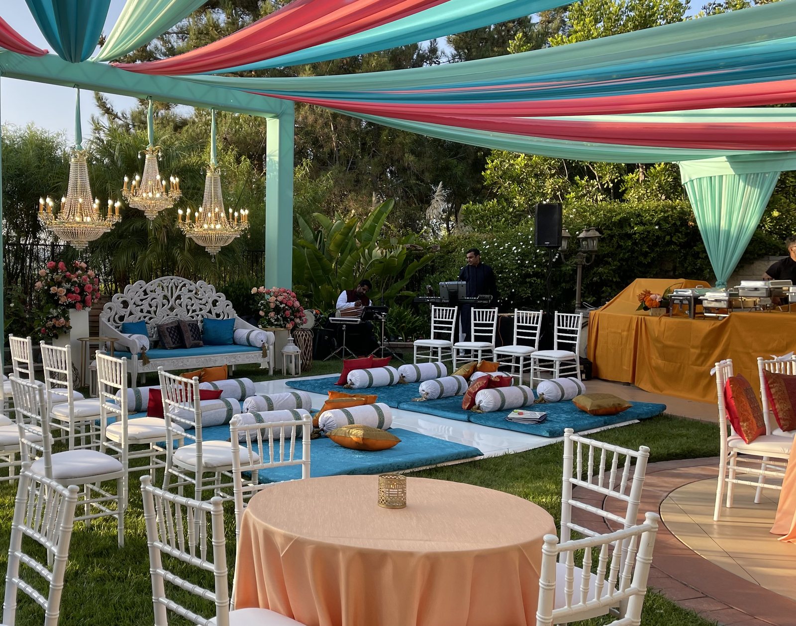 Draped canopy, chandeliers and seating styled for a Honest-catered event