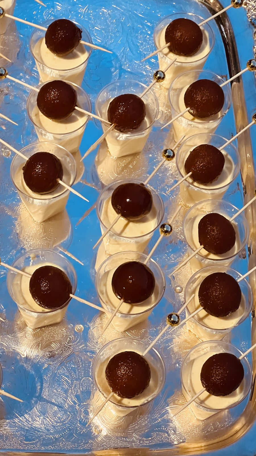 Gulab jamun served over shrikhand in individual cups, garnished for an event