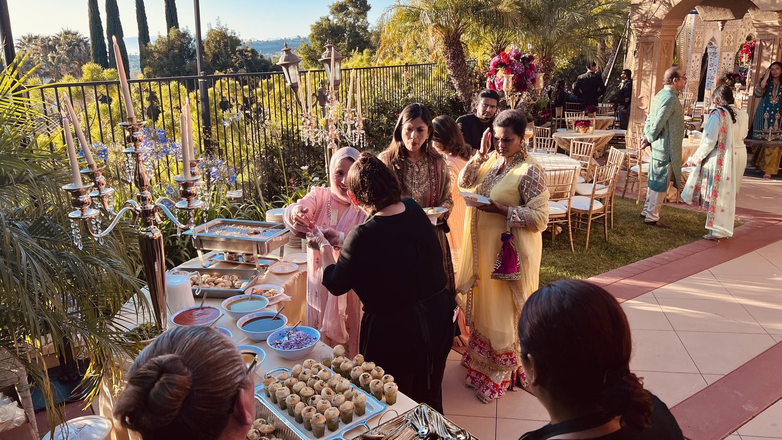 Guests plating fresh food at a Honest live catering station at an outdoor wedding